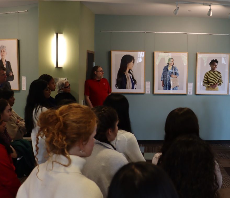 Students and audience gathered in the gallery listening to a talk among 200 Women portraits